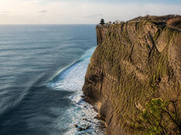 Limestone cliffs of Uluwatu dropping into the deep blue ocean at sunset
